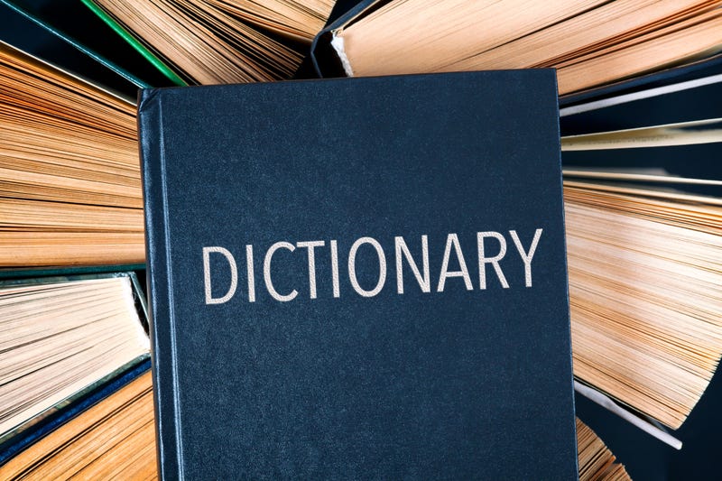 view of old hardcover books with book Dictionary on top