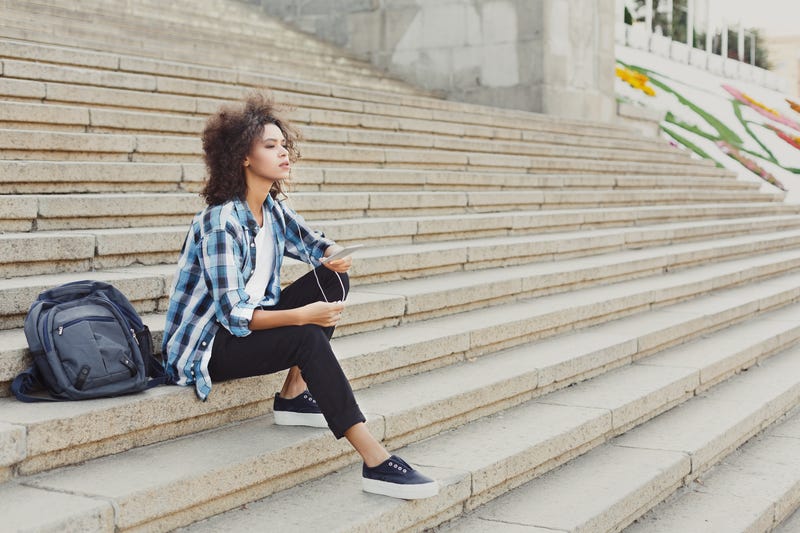 homesick female college student on university stairs