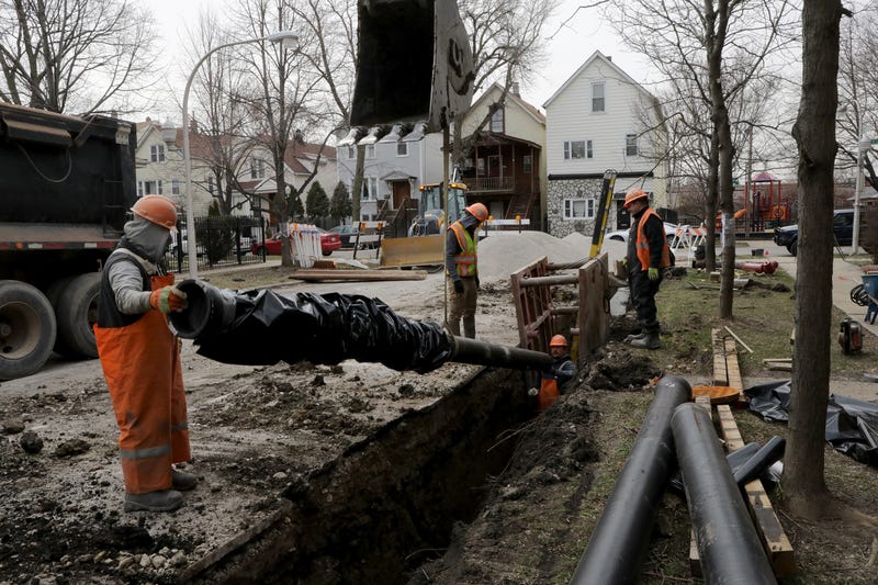 Chicago Department of Water Management crews install a 20-foot length, 8-inch water main pipe in the 3100 block of north Richmond Street on Monday, April 2, 2018, in Chicago.