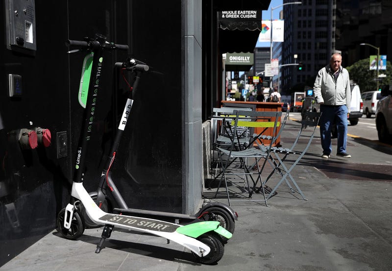 Bird and Lime scooters sit parked in front of a building on April 17, 2018 in San Francisco, California
