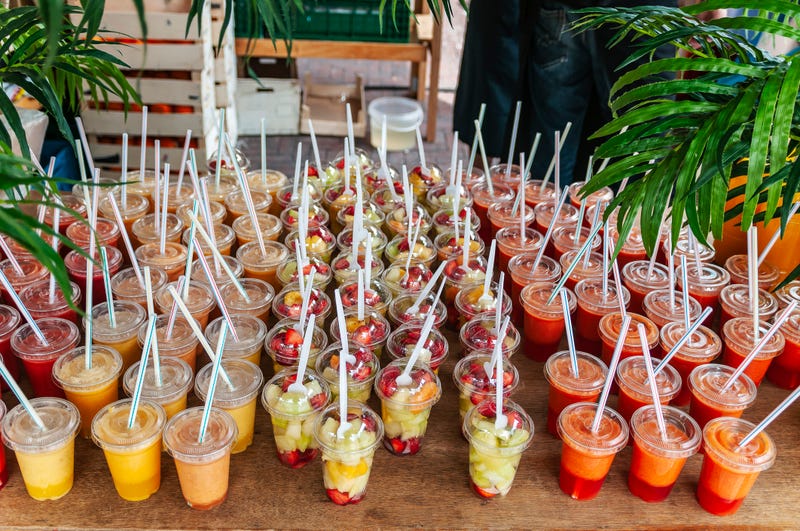 Cocktails in to-go cups with straws.