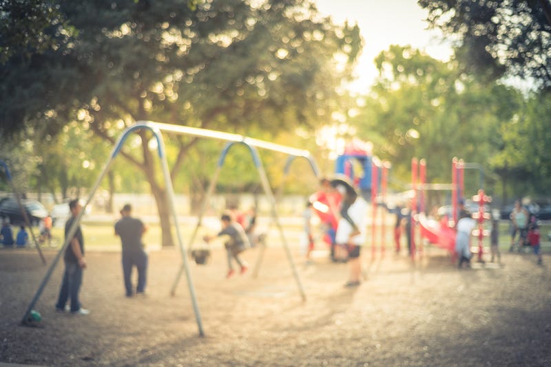 Blurred motion kids swing back and forth at public playground