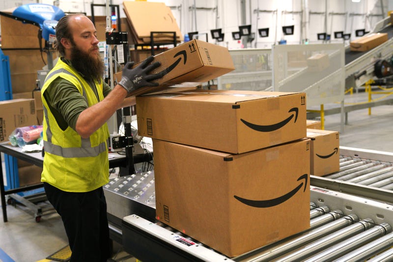 A worker moves packed boxes at the Amazon fullfillment center May 3, 2018 in Aurora, Colorado. The million square foot facility, employing 1,000 fulltime employees, has over 2 million products ready to ship to customers globally.