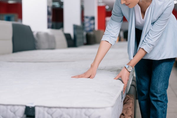 Woman inspects mattress in a store