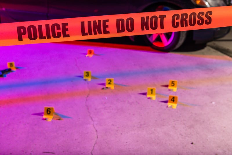 Cordon tape, marking a police line, is stretched in front of a crime scene