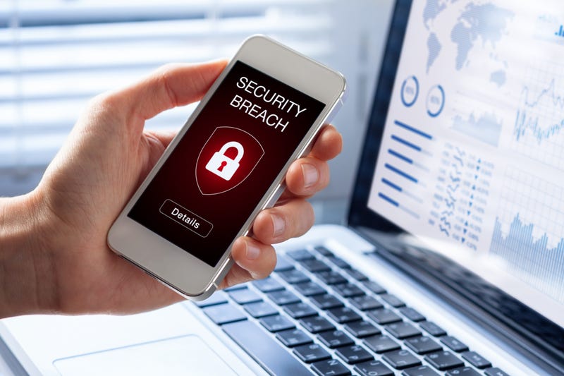 Man holding iPhone that says data breach