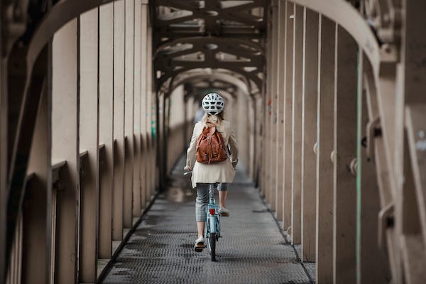 Woman cycling over a bridge