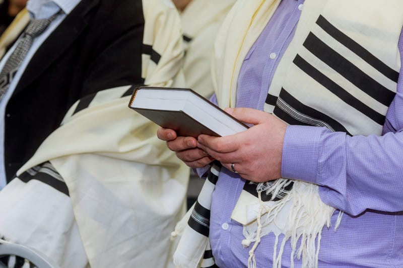 Hands holding a Jewish prayer book
