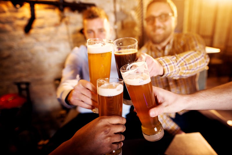 A group of young men clinking glasses with a beer