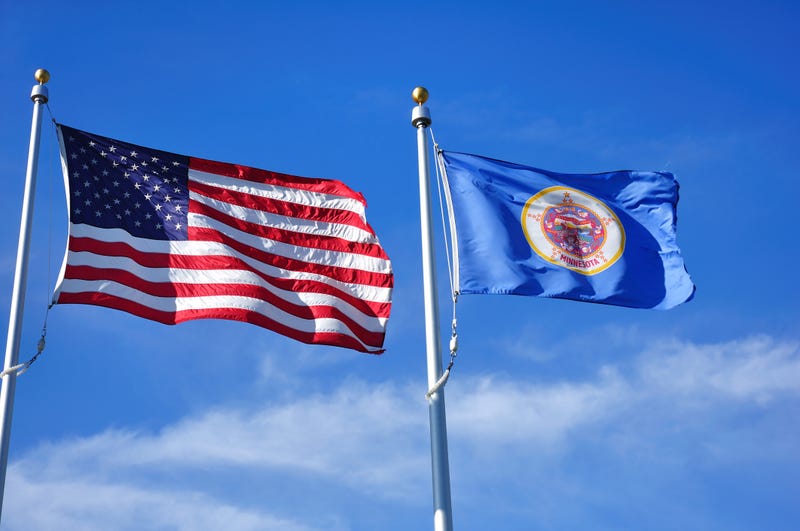 The United States and Minnesota state flag flying next to one another.