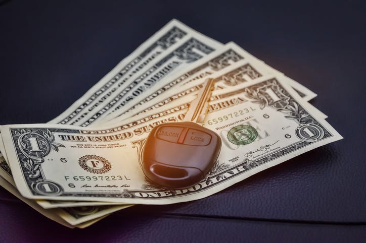 Car key on top of five one dollar bills