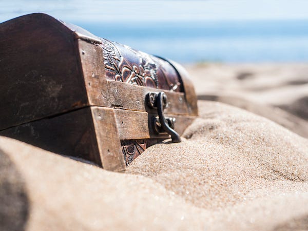 Locked chest, buried treasure on a beach