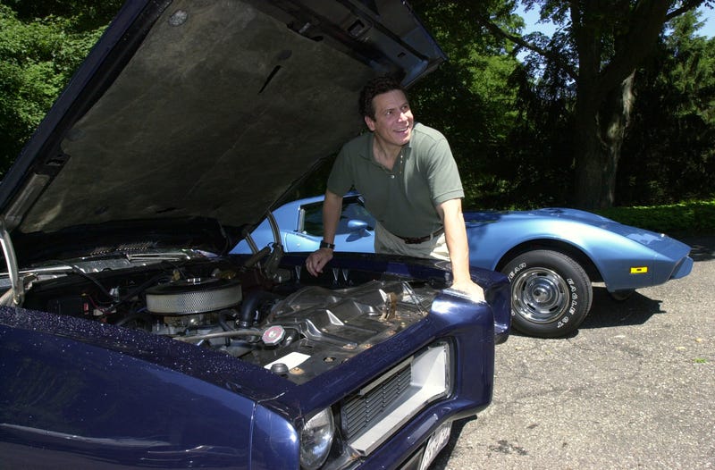 Then-gubernatorial hopeful Andrew Cuomo looks over his 1968 Pontiac GTO (front) and his 1975 Corvette at his Mount Kisco, New York, home on June 28, 2002