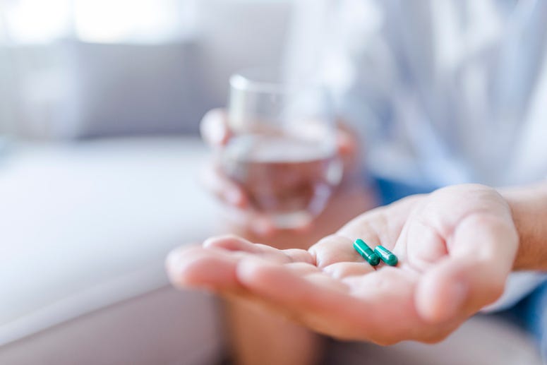 Man taking pills with a glass of water