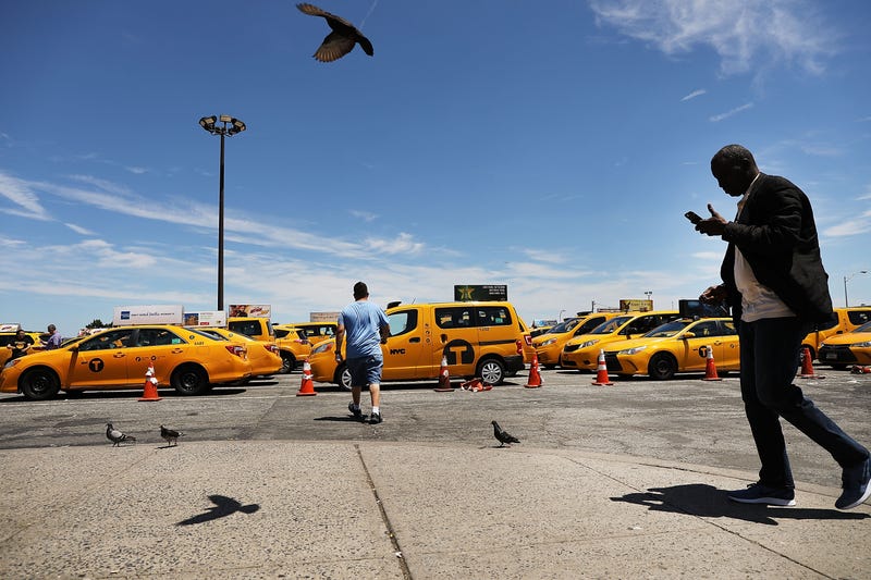 Taxi drivers gather at John F. Kennedy (JFK) Airport while waiting their turn to pick up a passenger.