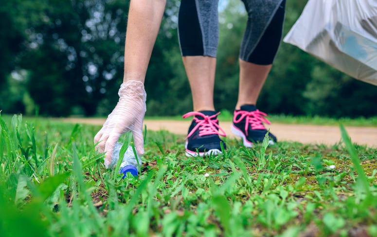 Woman picking up trash in park