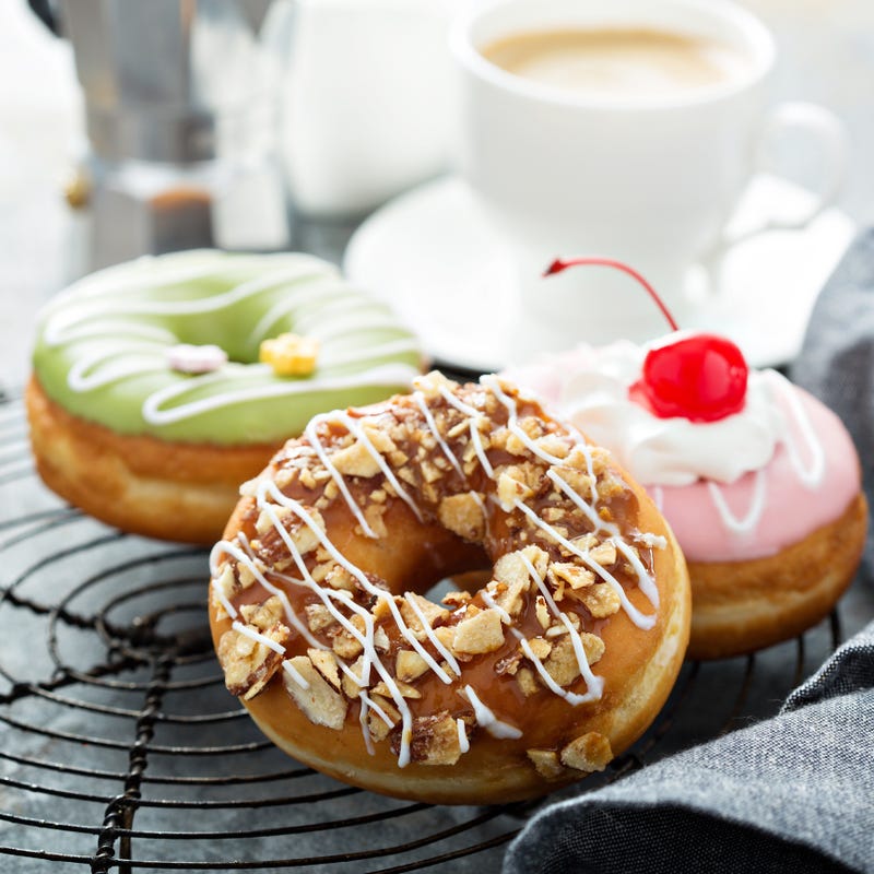 Assorted glazed fried donuts with coffee for breakfast