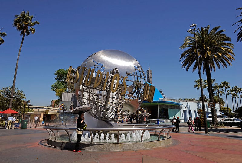 Tourists get their picture taken at the front entrance of Universal Studios Hollywood theme park on May 4, 2010 in Universal City, California.