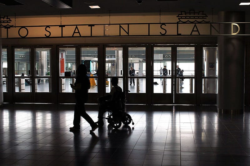 Passengers pass the entrance to the Staten Island Ferry on May 8, 2010 in New York City.