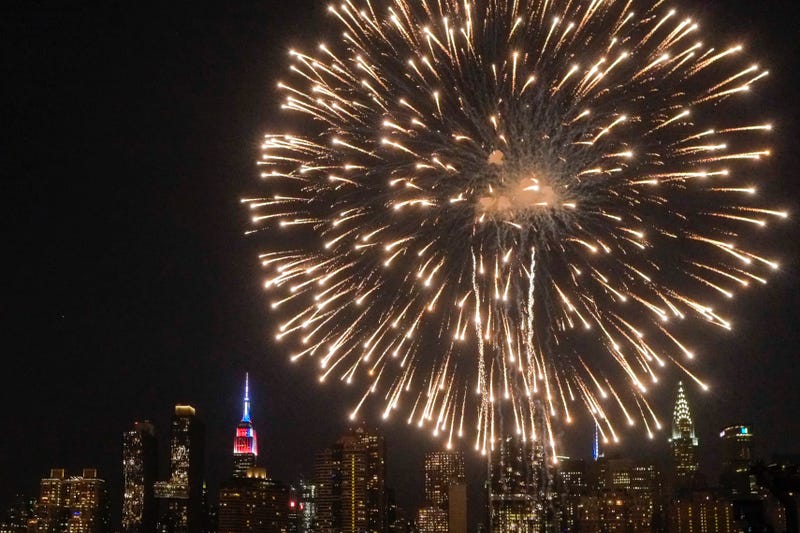 The Empire State Building is lit on blue, white and red as People watch the Macy's Fourth of July Fireworks from Hunter Point Park on July 4, 2018 in New York City