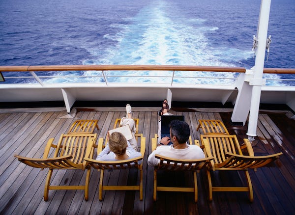 Couple laying on deck chairs on a cruise ship