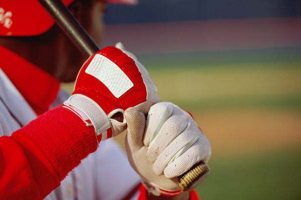 Baseball playing gripping bat, close-up 