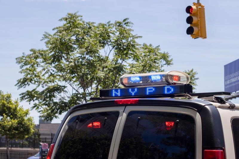 Closeup of a NYPD police car with flashing lights on the streets in the borough of Queens.