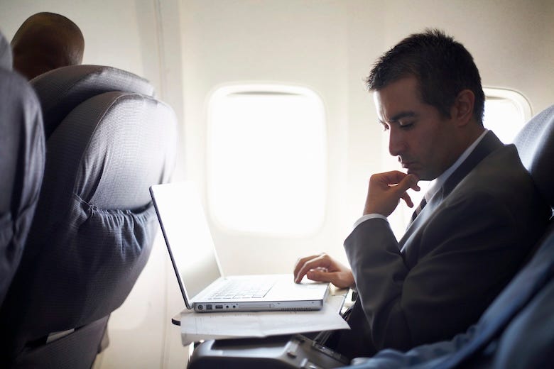 Businessman working on a laptop while on a flight