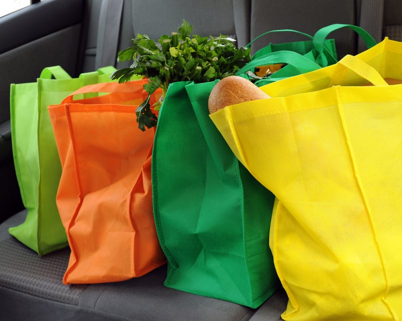 Four reusable shopping bags filled with groceries