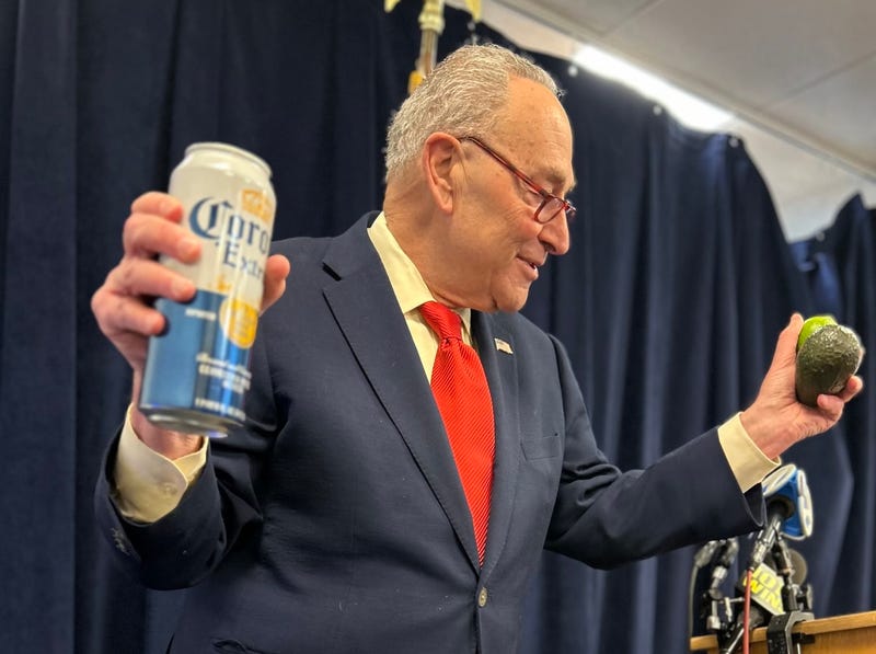U.S. Sen. Chuck Schumer holds up a Corona beer can, a lime and an avocado, Mexican imports he said will become more expensive due to new tariffs, at his office in Manhattan on Feb. 2, 2025