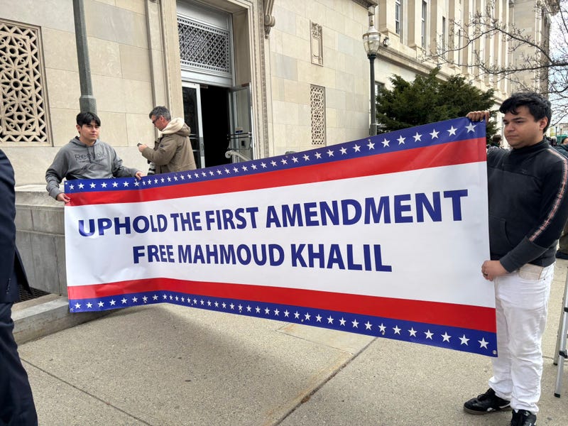 Protesters hold a banner supporting Khalil outside the courthouse on March 28, 2025