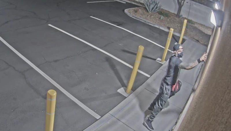 Man spray painting graffiti on a church wall, June 25th, 202