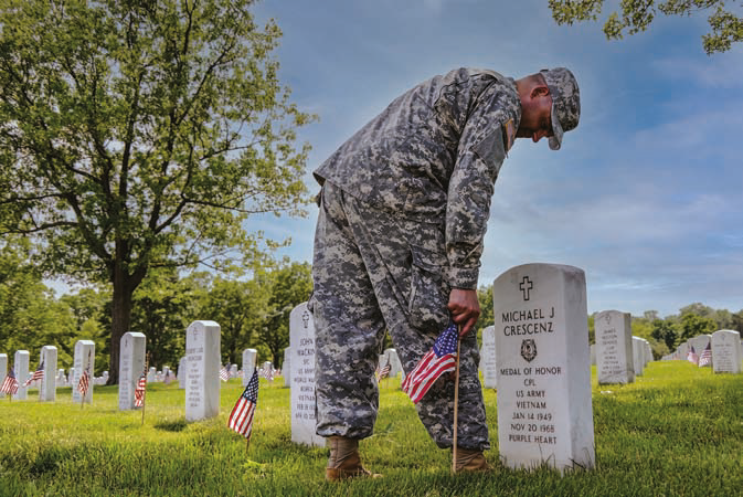 Soldier placing flag at Michael’s grave for Memorial Day, Arlington National Cemetery. 