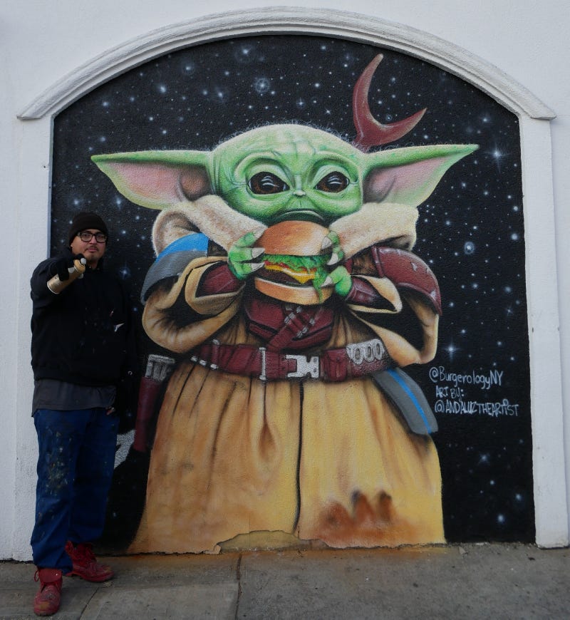 Andaluz stands next to one of his far-out murals.
