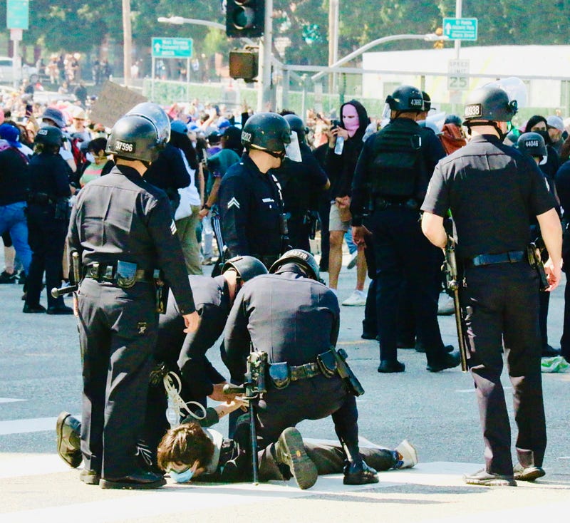 protester being arrested by police in street