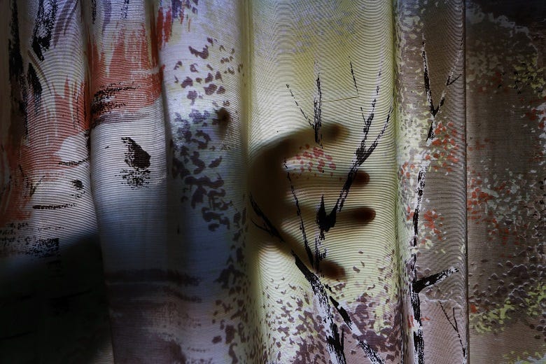 hand behind curtain