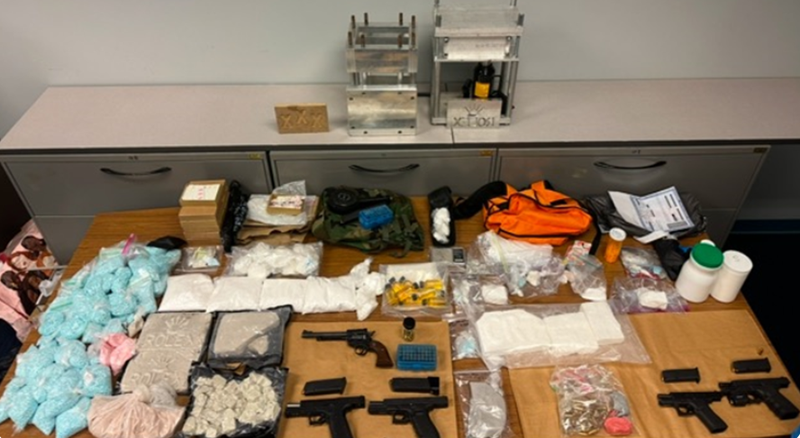 Some of the alleged narcotics and firearms seized during the investigation, including cocaine, counterfeit oxycodone pills containing fentanyl, powder fentanyl, five handguns, four high-capacity magazines, and “kilo” presses.