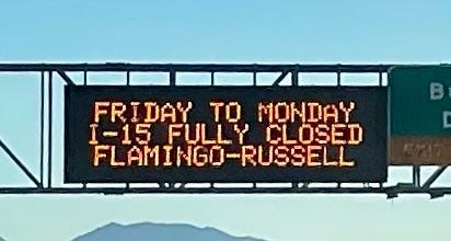 An overhead freeway sign warns drivers of an impending closure of I-15