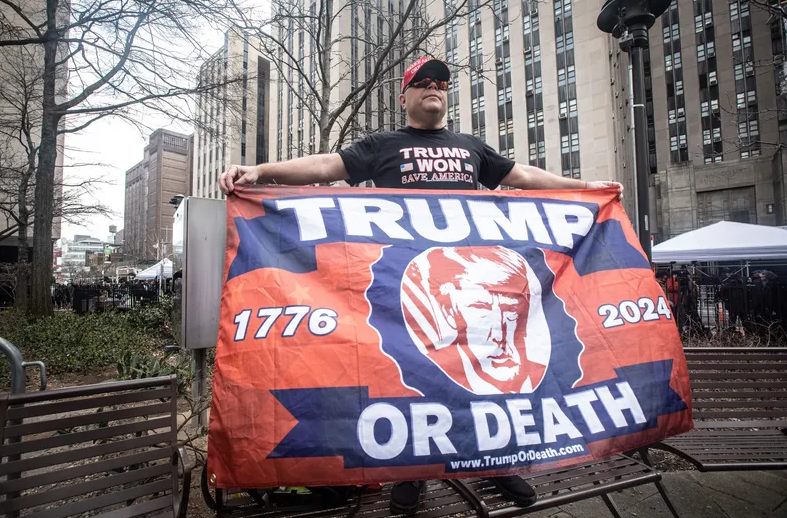Trump supporter Dion Cini of Brooklyn holds a sign across the street from the Manhattan Criminal Courthouse April 4, 2023, before the arraignment of the former president
