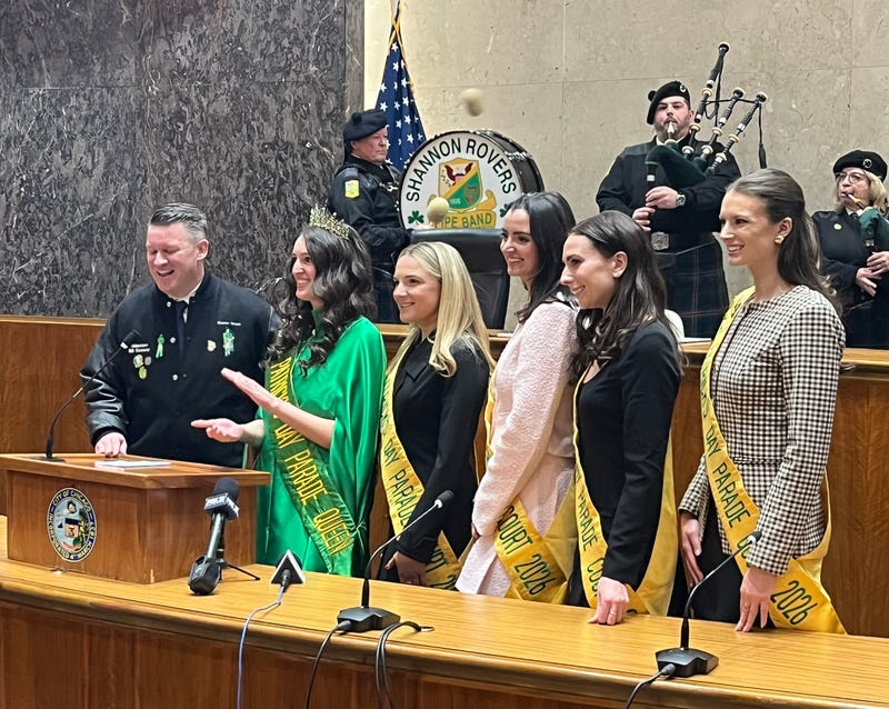 Chicago Ald. Bill Conway (34th Ward) welcomes St. Patrick's Parade Queen Claire Cahill and her court to City Council chambers, as members of the Shannon Rovers bagpipe corps look on.