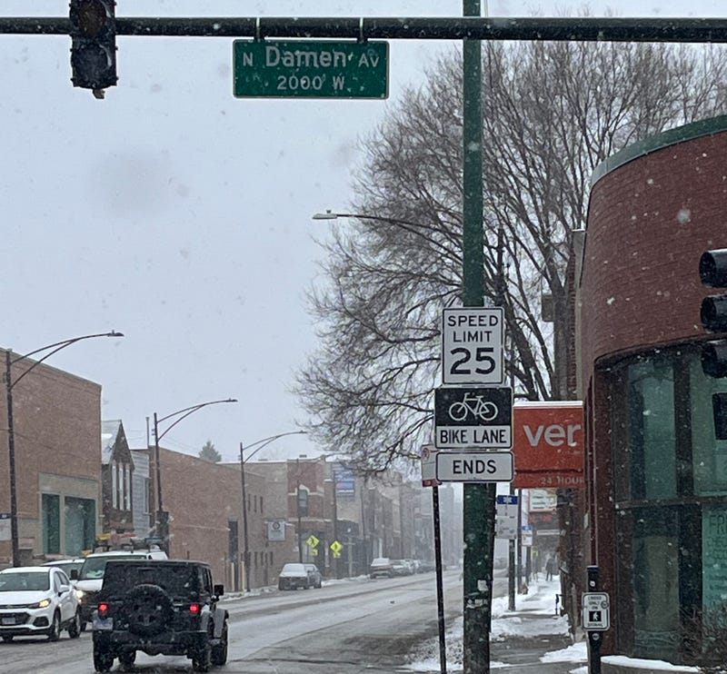 A sign on West Grand Avenue past Damen Avenue notes where a protected bike lane ends in Chicago's West Town neighborhood.