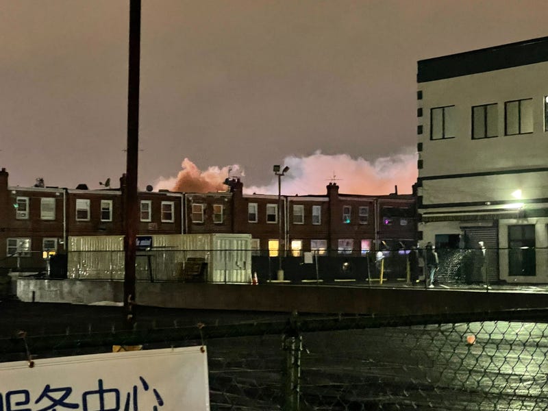 A plume of smoke rises above the neighborhood near the site of the medical transport jet crash on Friday.