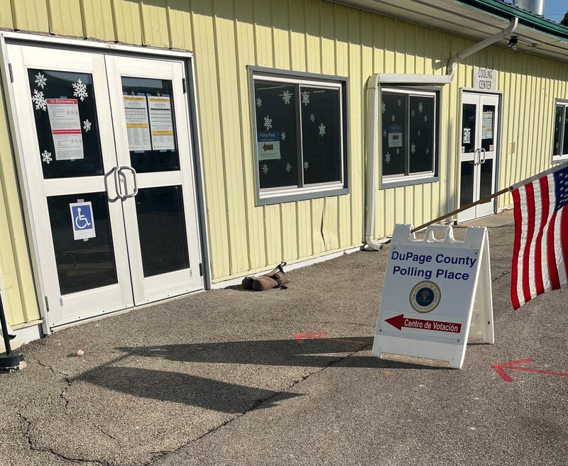 A sign in English and Spanish stands outside the voting precinct at the DuPage County Fairgrounds in Wheaton.