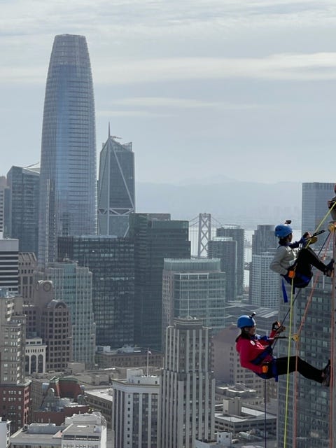 Volunteers rappel down the side of a San Francisco hotel.
