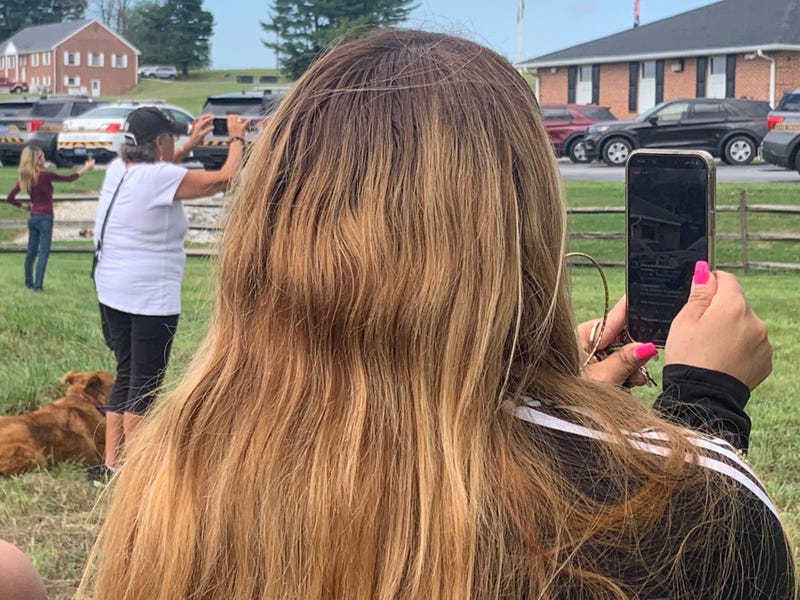 Community members snap photos of recaptured convicted murderer Danelo Cavalcante.