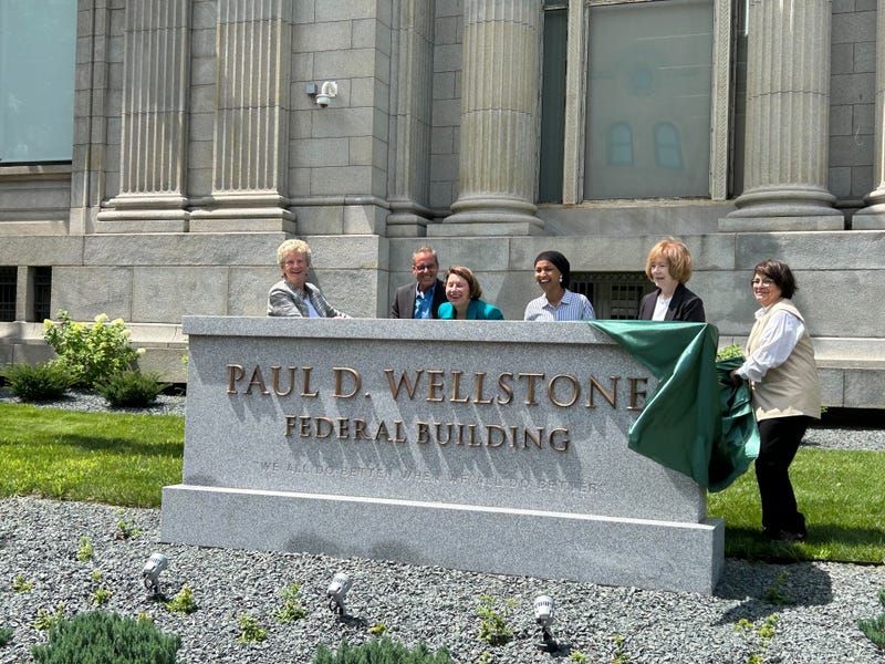 Dignitaries including Rep. Ilhan Omar and Senators Amy Klobuchar and Tina Smith, show off the new name of a Minneapolis Federal Building named for the late Senator from Minnesota, Paul Wellstone, who died in 2002.