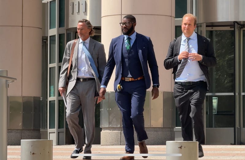 Sheriff Alfred Montgomery, flanked by his lawyers, exits the federal courthouse after his initial indictment