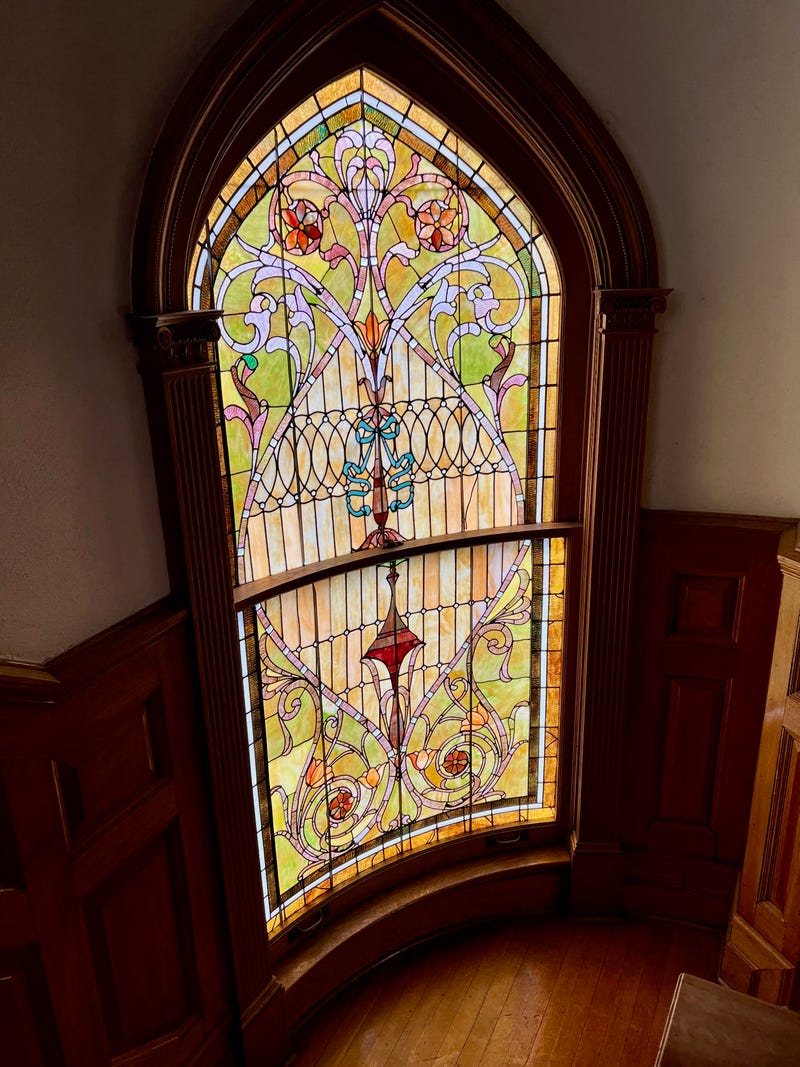 curved stained glass window on a staircase landing in the Hadley House in Edwardsville, IL