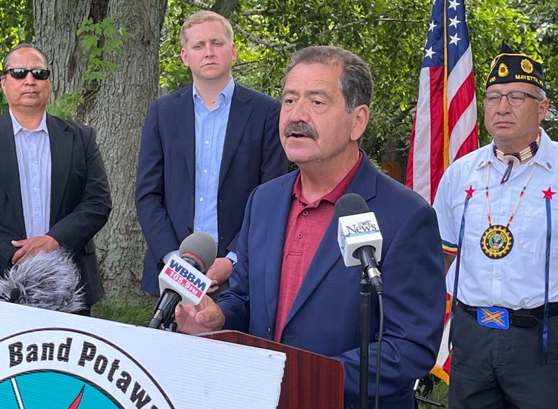 Jesus Garcia speaks at a podium while three people stand behind him