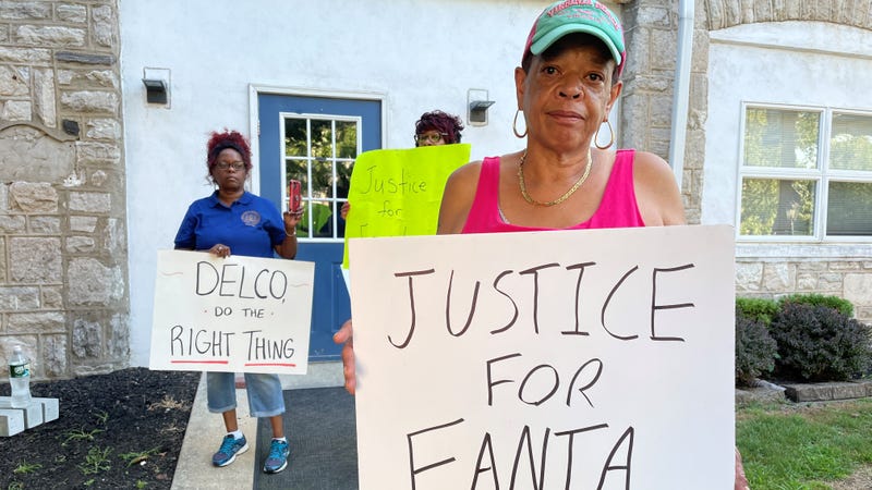 Protesters holding signs in response to the heavily-redacted report about Sharon Hill police shooting and killing Fanta Bility, 8, last year at a high school football game.